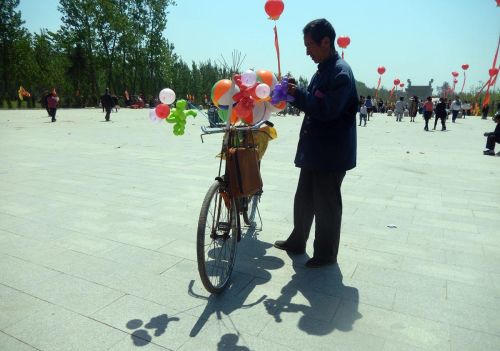 农村老汉骑古董自行车卖气球，生意好的时候能挣个百儿八十的