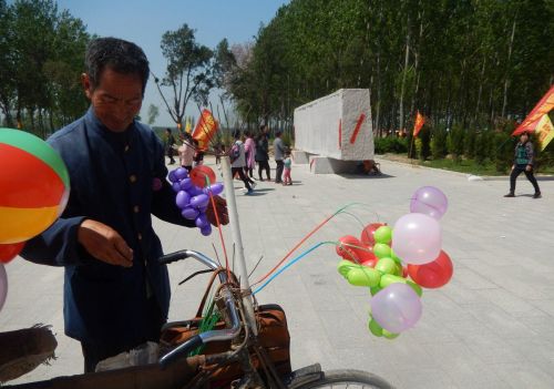 农村老汉骑古董自行车卖气球，生意好的时候能挣个百儿八十的