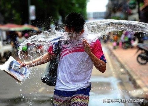  女子泼水节被众男子围着泼水撕雨衣，制止不文明现象，泼水节泼女生