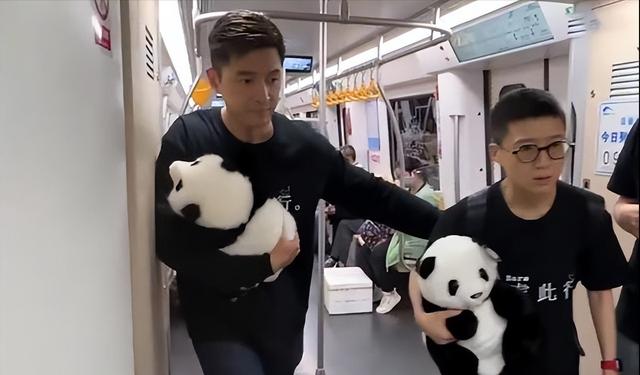胡歌抱国宝现身地铁（和剧组人员抱着熊猫玩具乘车）(6)